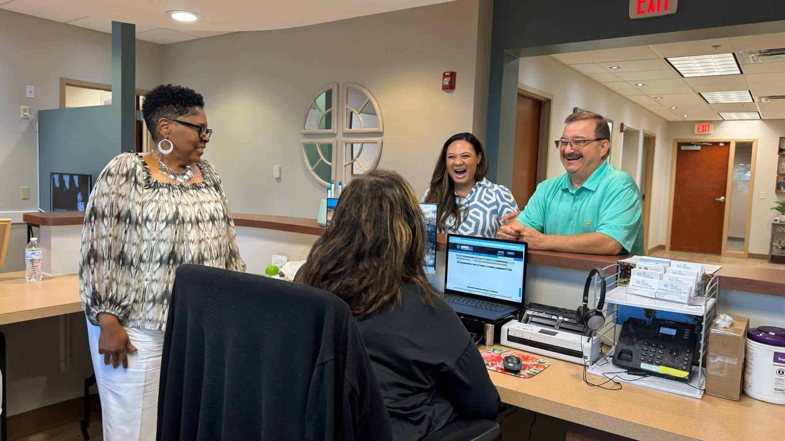 The All About Audiology team greeting patients at the front desk